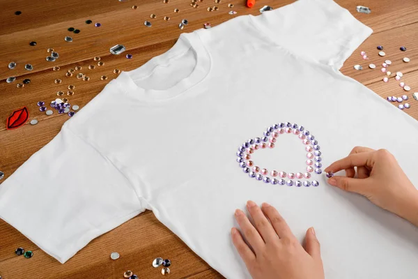 Kvinna tillämpa strass till t-shirt — Stockfoto