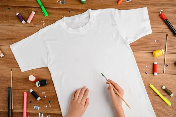 Girl painting on a t-shirt — Stock Photo, Image