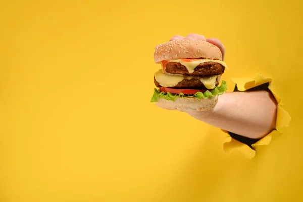 Mano prendendo un hamburger grande — Foto Stock