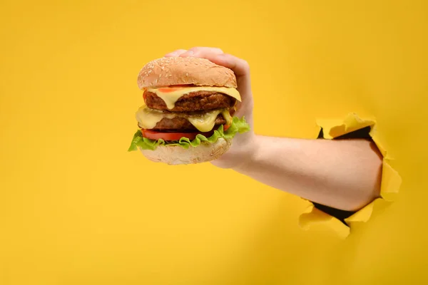 Hand met een grote hamburger — Stockfoto