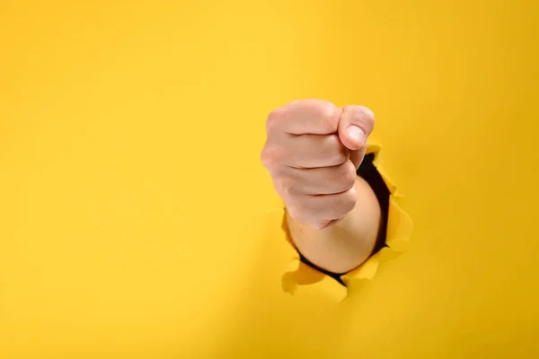 Fist broke yellow paper wall