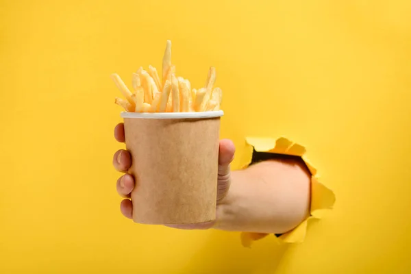 Mão dando batatas fritas — Fotografia de Stock