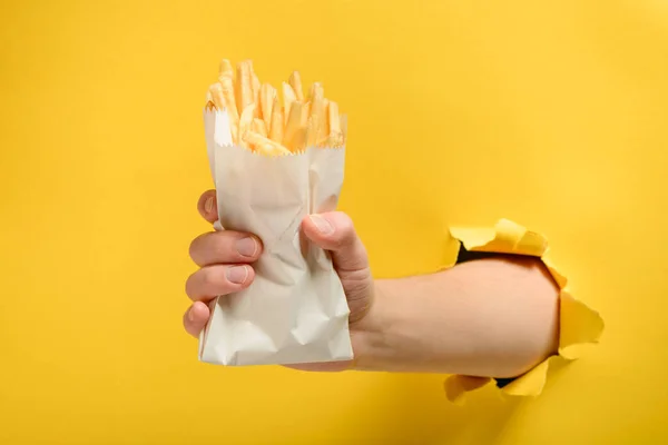 Mão tomando batatas fritas — Fotografia de Stock