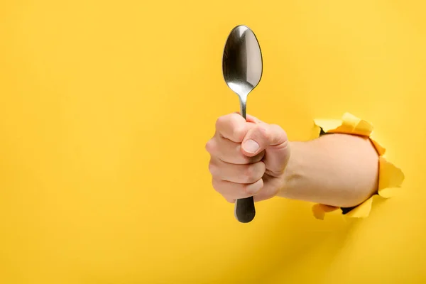 Hand holding a spoon