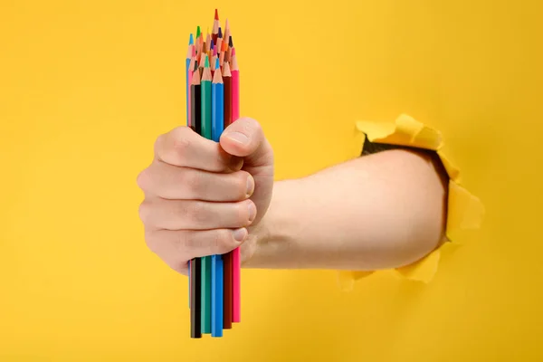 Hand giving colored pencils — Stock Photo, Image
