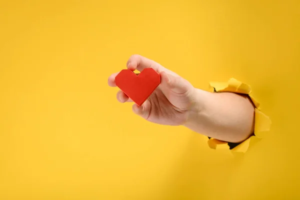 Mano sosteniendo un corazón rojo —  Fotos de Stock