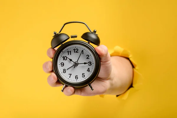 Hand showing an alarm clock