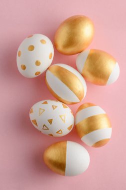 Pembe bir arka plan üzerinde altın yumurta