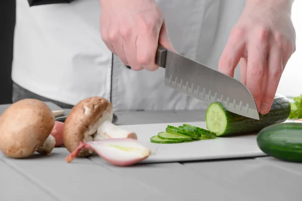 Mans mani tagliando un cetriolo — Foto Stock