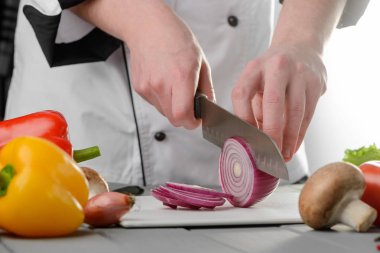 Professional chef cutting red onion clipart