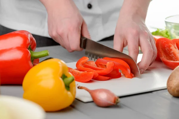 Homem cortando uma pimenta vermelha — Fotografia de Stock