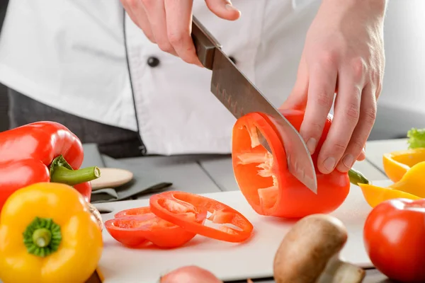 Chef cortando uma pimenta vermelha — Fotografia de Stock
