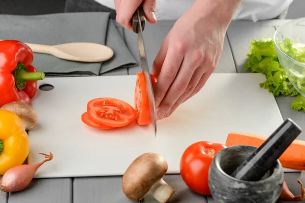 Man snijden een sappige tomaat — Stockfoto