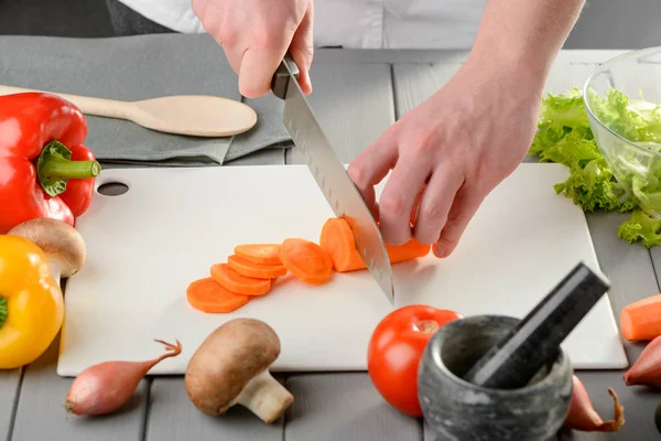 Chef-kok snijden een wortel — Stockfoto
