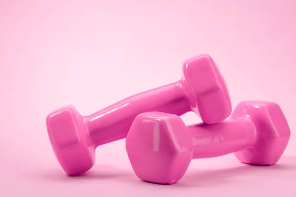 Pair of dumbbells on pink