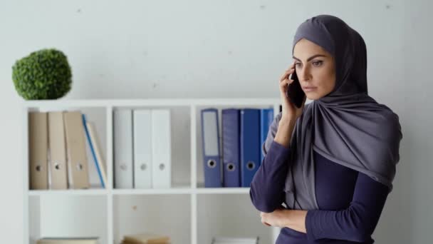 Müslüman iş kadını çalışanıyla telefon görüşmesi yapıyor. Kadın patron sert tavır sergiliyor ve sinirli ruh hali içinde.. — Stok video