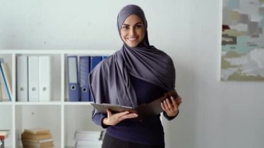 Elinde belgeler olan heyecanlı Müslüman kadın.