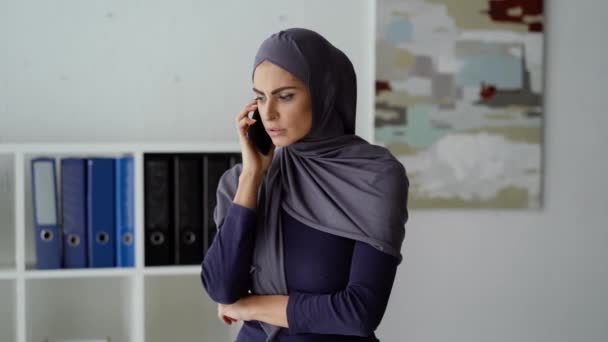 Serieuze Arabische dame in onderhandeling aan de telefoon — Stockvideo
