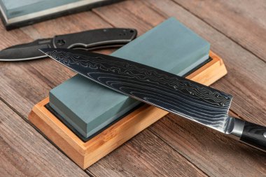 Sharpening a Japanese Gyuto knife and a jackknife with a whetstone clipart