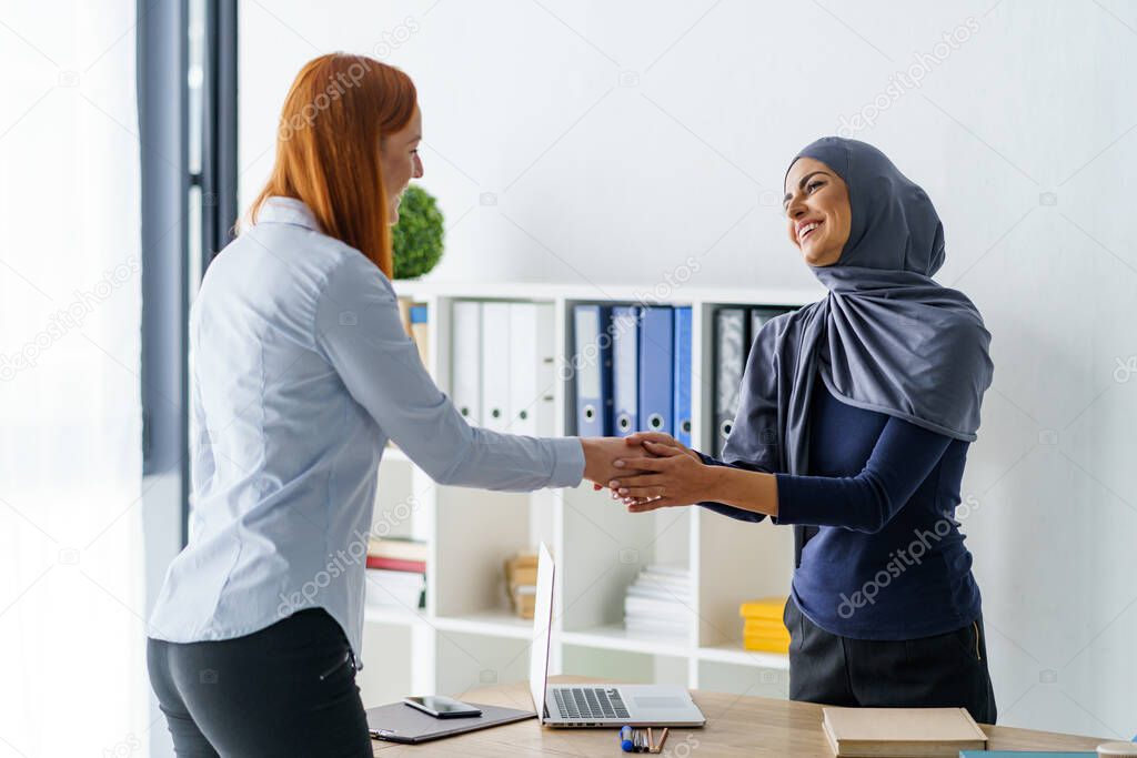 Women shaking hands each other at office