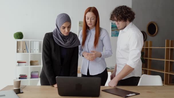 Equipe de negócios discutindo um projeto e olhando para um laptop — Vídeo de Stock