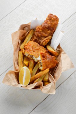Yağsız kağıtta limonlu balık ve patates kızartması.