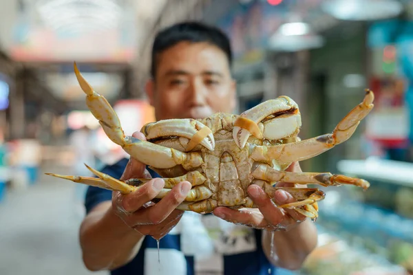 El hombre muestra un cangrejo con garras atadas —  Fotos de Stock