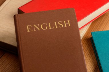 Masada bir yığın kitap var. Dilbilgisi kitabıyla İngilizce öğreniyorum.