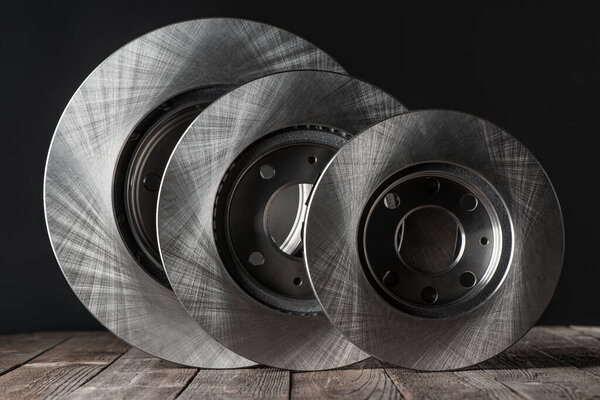Set of various brake discs on rustic wooden table