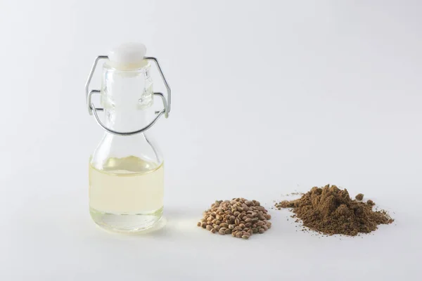 A bottle of hemp oil, seeds and a handful of flour on white background — Stock Photo, Image