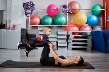 Anne mindere uzanıp çocuğuyla oynuyor.