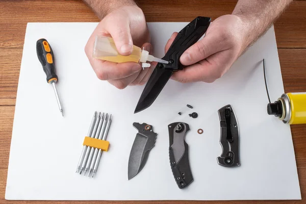 Reparador adicionando um pouco de óleo doméstico nas articulações de uma faca dobrável — Fotografia de Stock