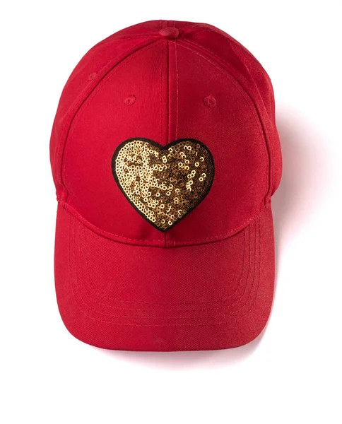 Red cap with golden sequin heart patch on white background — Stock Photo, Image