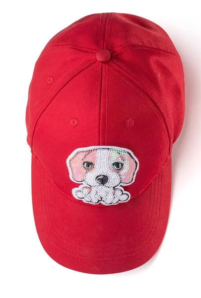 Red cap with a sequin dog patch on white background — Stock Photo, Image