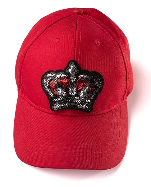 Red cap with a sequin crown patch on white background — Stock Photo, Image