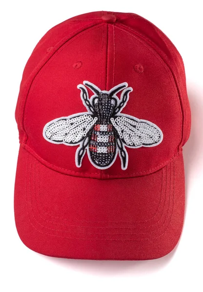 Red cap with a silver sequin fly patch on white background — Stock Photo, Image