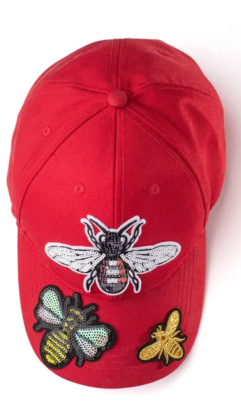 Casquette rouge avec une paillettes d'insectes brodées de paillettes d'argent sur fond blanc — Photo