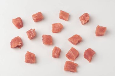 Beyaz arka planda küçük küplere doğranmış taze domuz eti. Pişirme g
