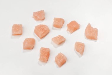 Chicken fillet diced into small cubes on white background clipart