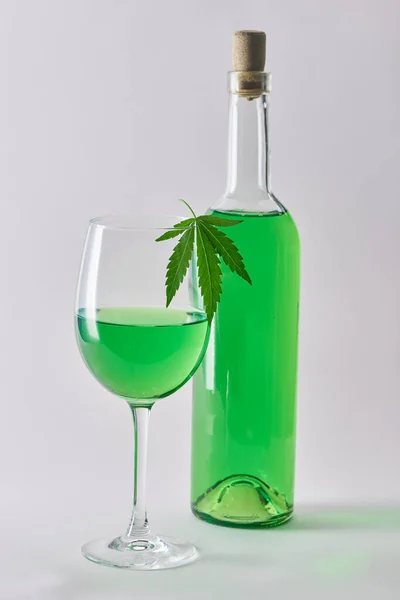 Szklanka i butelka zielonego wina z konopi na białym tle — Zdjęcie stockowe