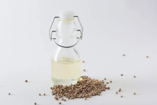 A little bottle of hemp oil and seeds on white background — Stock Photo, Image