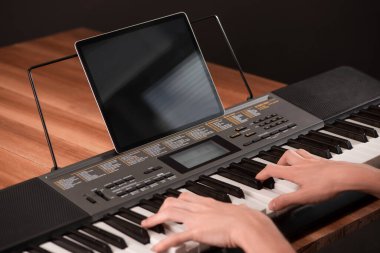 Çocuk bir öğretmenle çevrimiçi ders sırasında piyano çalmayı öğreniyor.