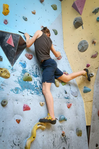 Teenage Boy Training Climbing On Indoor Climbing Wall