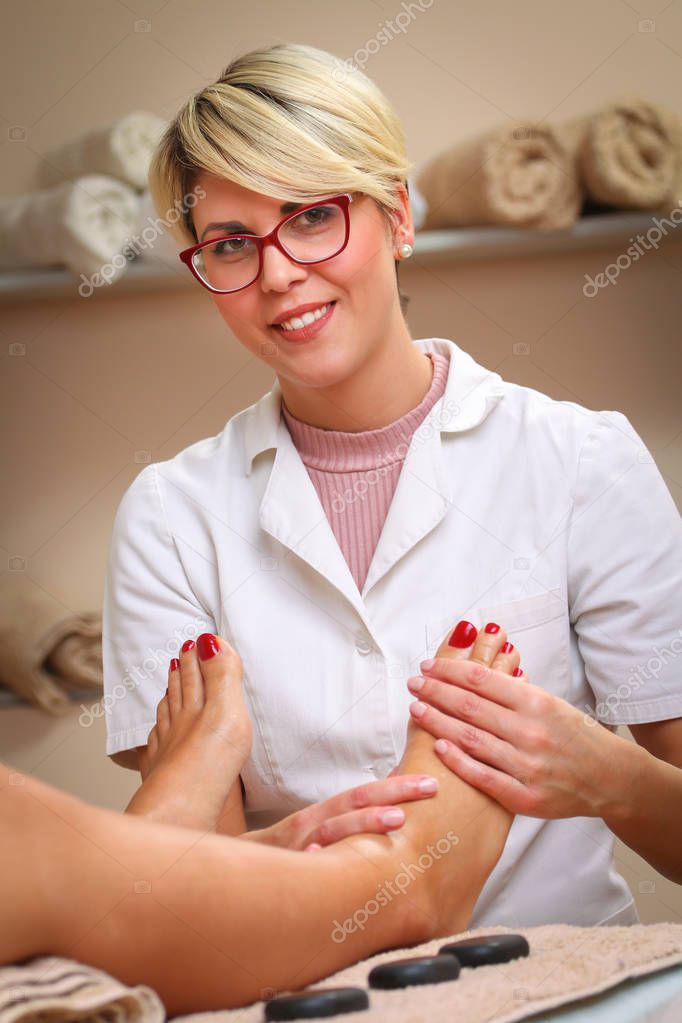 Massage therapist massaging legs of pregnant woman