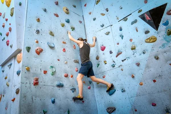 Teenage Boy Training Climbing On Indoor Climbing Wall