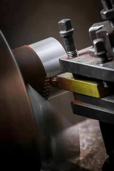 Metal worker shaping metal on lathe