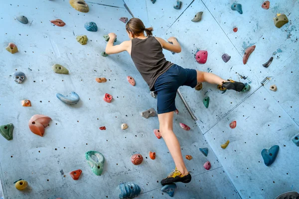 Teenage Boy Training Climbing On Indoor Climbing Wall