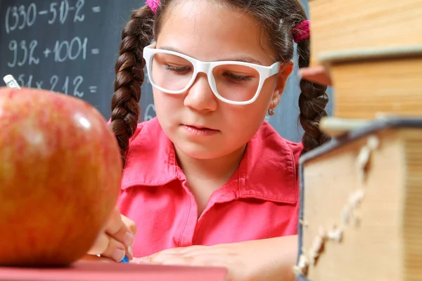 Happy school girl in front of the blackboard