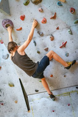 Genç çocuk üzerinde kapalı tırmanma duvarı tırmanma eğitimi