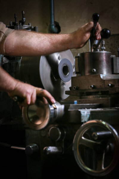 Металлообработчик, формирующий металл на токарном станке
